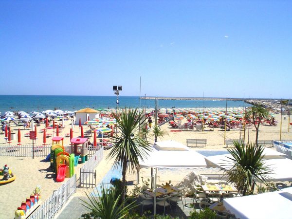 Spiaggia con ombrelloni colorati e giochi per bambini.