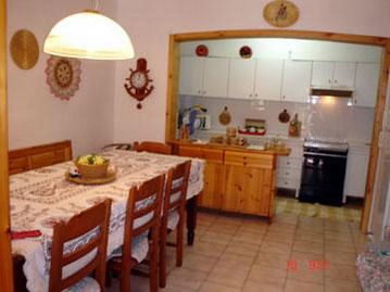 Sala da pranzo con tavolo e sedie di legno.