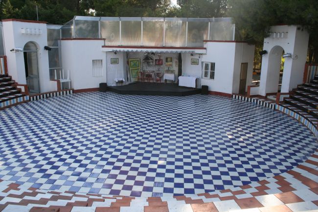 Anfiteatro vuoto con pavimento a scacchiera blu e bianco.