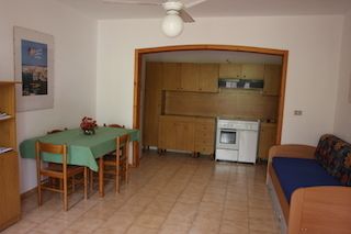 Cucina con tavolo verde e divano blu.