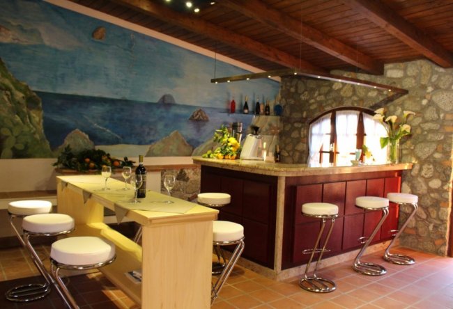 Interno bar elegante con sgabelli e murale marino.