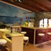 Interno bar elegante con sgabelli e murale marino.