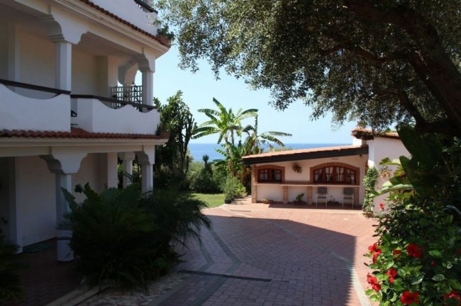 Giardino con villetta e vista mare.