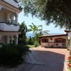 Giardino con villetta e vista mare.