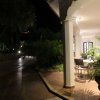 Portico esterno illuminato di notte con piante e tavolo.