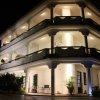 Edificio a tre piani con balconi illuminati di notte.