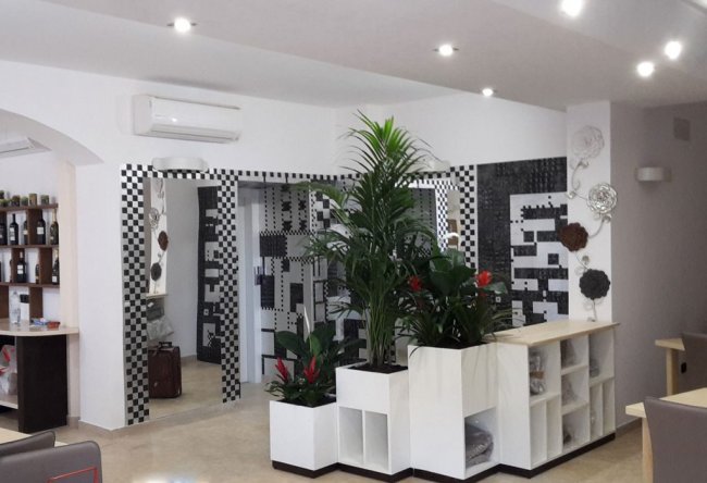 Hall moderna con piante e motivi geometrici sulle pareti.