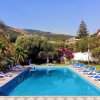 Piscina all'aperto con sdraio blu e vista su montagne.