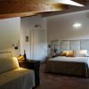 Camera con letto matrimoniale, divano e travi in legno.