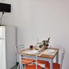 Tavolo da pranzo con quattro sedie e frigorifero.