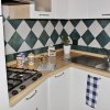 Cucina angolare con piastrelle a rombi verdi e bianche.