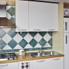 Cucina moderna con cappa, fornelli e frigorifero.