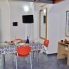 Sala da pranzo con tavolo apparecchiato e sedie arancioni.