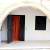 Arco in muratura con porta e finestra scuri neri.