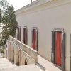 Facciata di un edificio con finestre rosse e balcone.