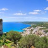 Panorama costiero con mare azzurro e case bianche.