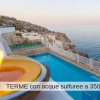 Piscina vista mare con candele accese.