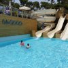 Piscina con scivoli e due persone che nuotano.