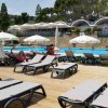 Lettini e ombrelloni accanto a una piscina.