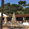 Tavoli e sedie all'aperto con ombrelloni bianchi.