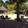 Area giochi con palme e ombrelloni di paglia.
