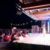 Spettacolo serale su un palco all'aperto con pubblico.