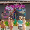 Bambini in costume partecipano a un evento su un palco.
