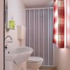 Un bagno con lavabo, WC e tenda a quadri.