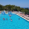 Piscina all'aperto con lettini e vista mare.
