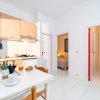 Cucina luminosa con tavolo apparecchiato e due ingressi.