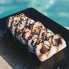 Rotoli di sushi su piatto nero.