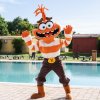 Mascotte arancione e bianca vicino a una piscina.