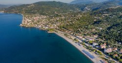 Vista costiera con spiaggia e colline.