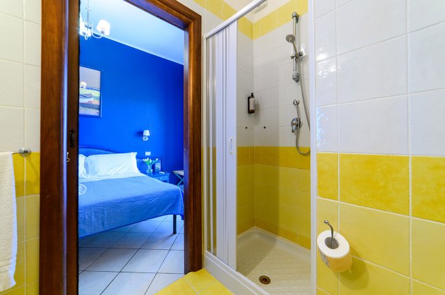 Doccia con porta scorrevole, vista stanza.