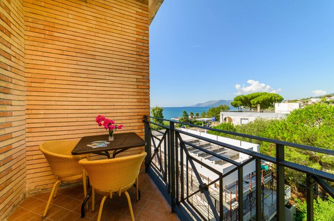 Balcone con tavolo, sedie e vista mare.