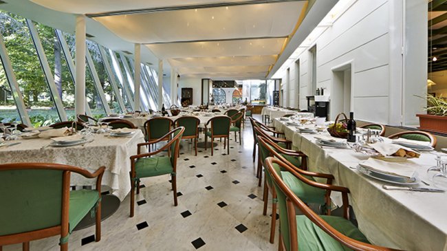 Sala da pranzo elegante con tavoli apparecchiati.