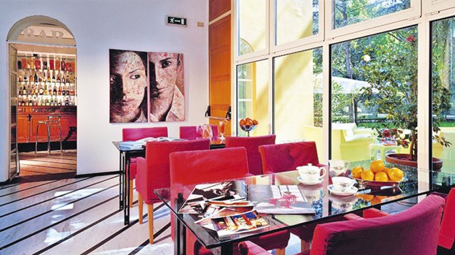 Sala con sedie rosse vicino a un bar.