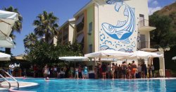 Piscina circondata da un hotel con murale blu e bianco di un pesce.