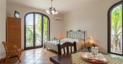 Camera con letto, tavolo e grandi finestre.