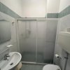 Un bagno con doccia, WC e lavabo con specchio.