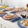 Buffet con dolci assortiti, torte e frutta su un tavolo imbandito.