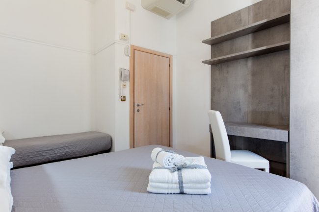 Camera da letto con letto matrimoniale e scrivania.