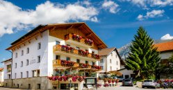 Struttura montana con balconi pieni di fiori.