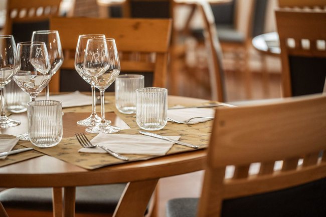 Tavolo apparecchiato con calici e tovaglioli.
