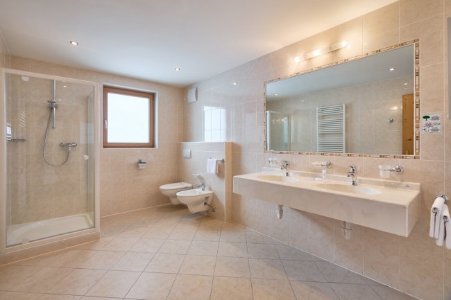 Bagno spazioso con doccia, lavabo doppio e sanitari.