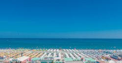 Vista dall'alto di un'ampia spiaggia con ombrelloni.