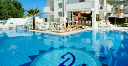 Piscina blu riflettente, lettini e palme.