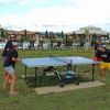 Quattro persone giocano a ping pong all'aperto.