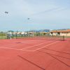 Un campo da tennis rosso all'aperto in una giornata serena.
