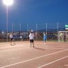 Partita di calcetto su campo illuminato di sera.